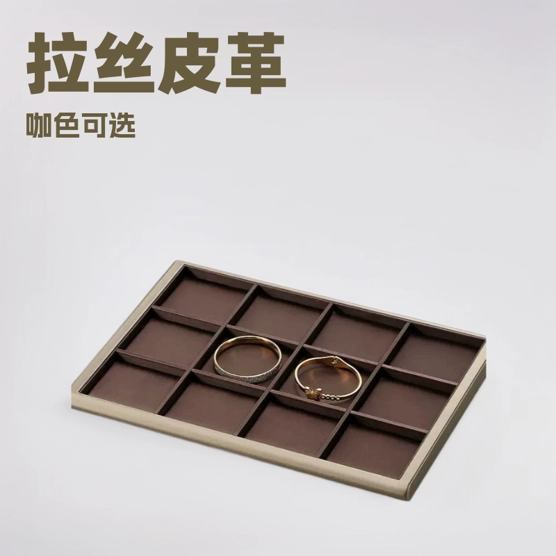 Подставка для ювелирных украшений из серой шлифованной кожи с коричневым колье, кольцом и серьгами